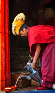 Monk in Tashilhunpo with giant aluminium teapot